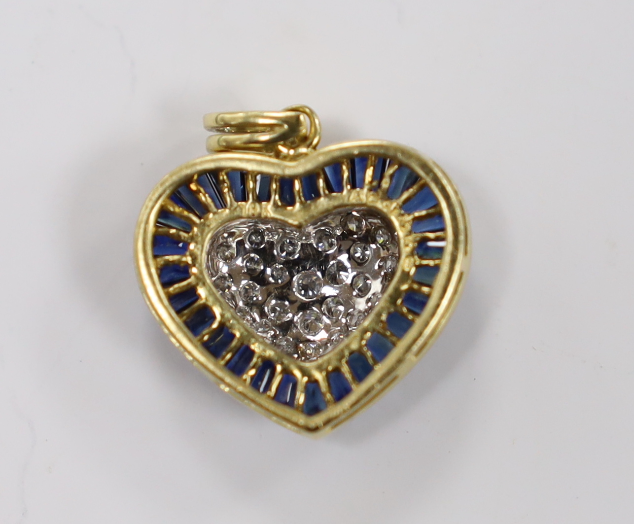 A modern 18k and heart shaped diamond cluster set pendant, with shaped cut sapphire set border, 19mm, gross weight 4.8 grams.